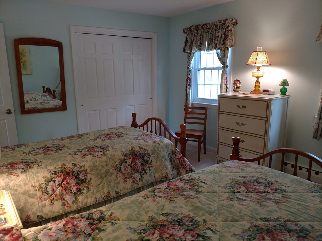 683 Old Post Road, Unit 18 Dennis, MA 02638 - Photo 15 of 25 a bedroom with a bed and a dresser with mirror