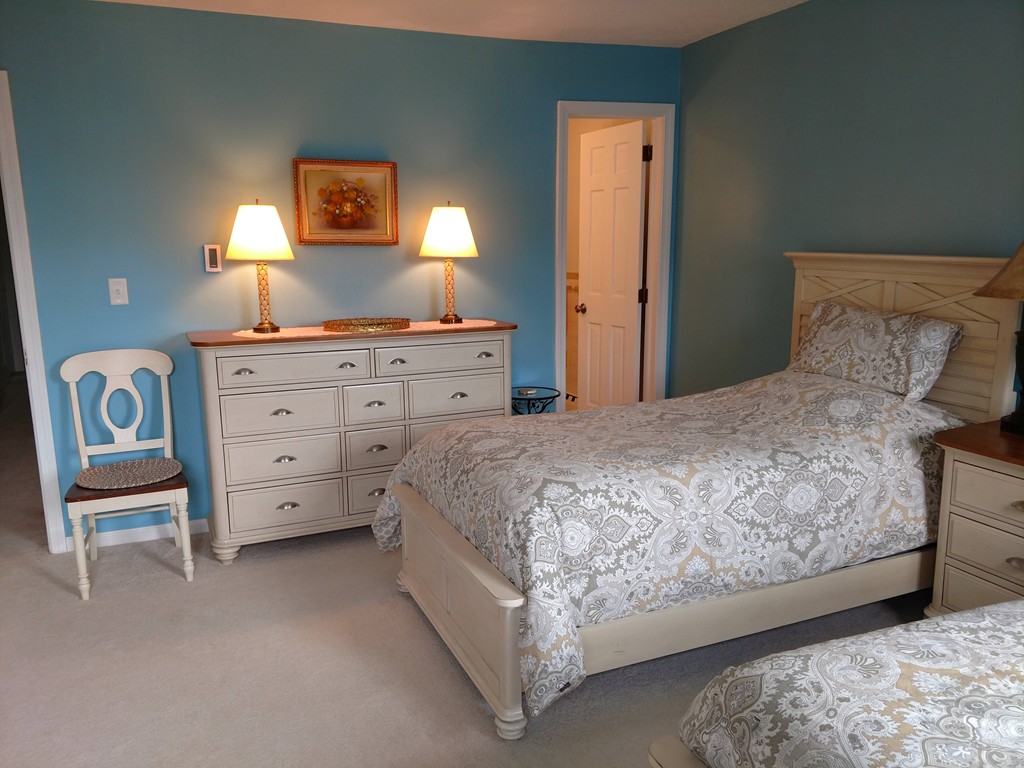 683 Old Post Road, Unit 18 Dennis, MA 02638 - Photo 10 of 25 a bedroom with a bed and a lamp on dresser