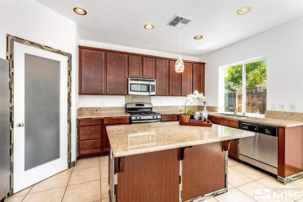 2050 Bears Ranch Drive Reno, NV 89521 - Photo 3 of 21 a kitchen with stainless steel appliances granite countertop a stove refrigerator sink and cabinets