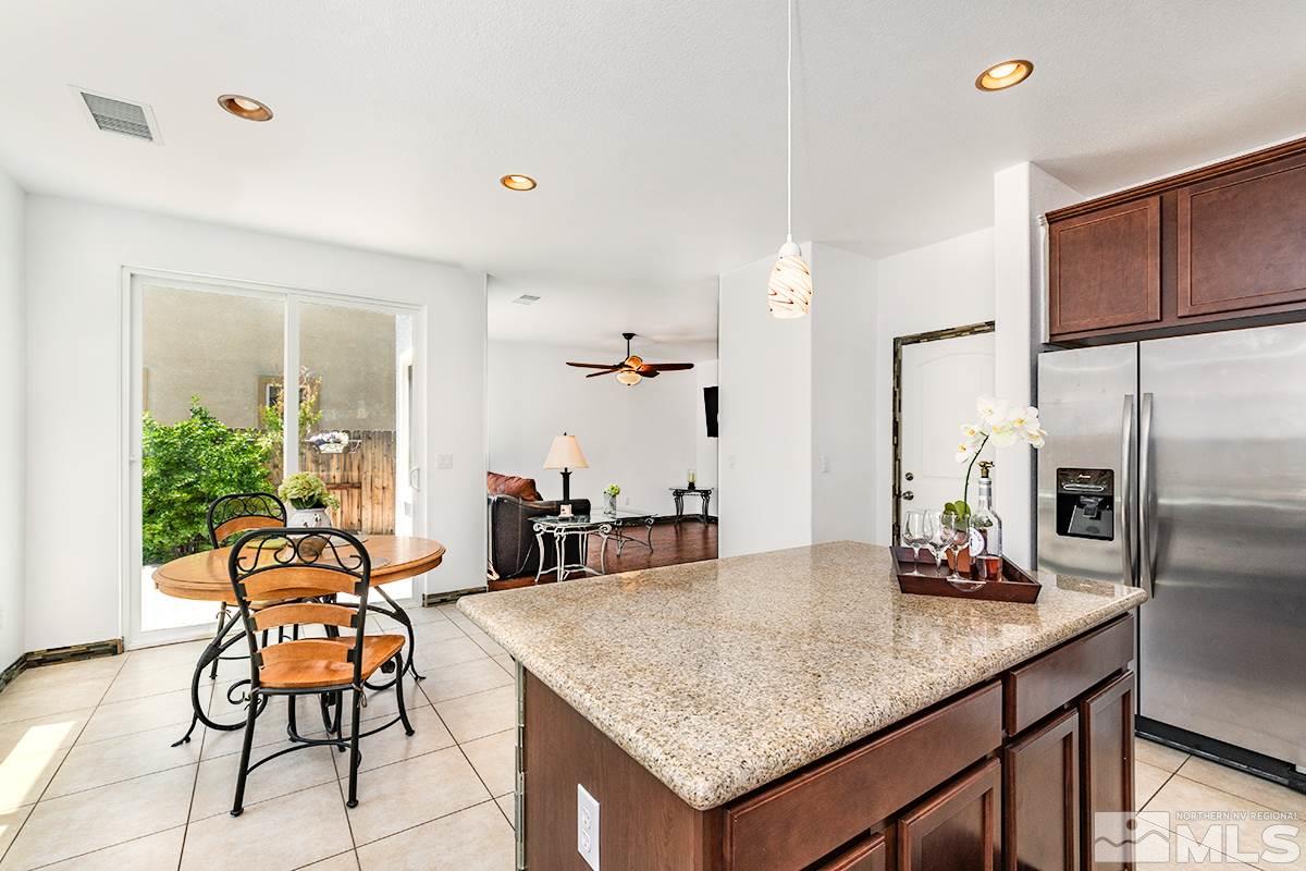 2050 Bears Ranch Drive Reno, NV 89521 - Photo 5 of 21 a kitchen with granite countertop a table chairs stove and refrigerator