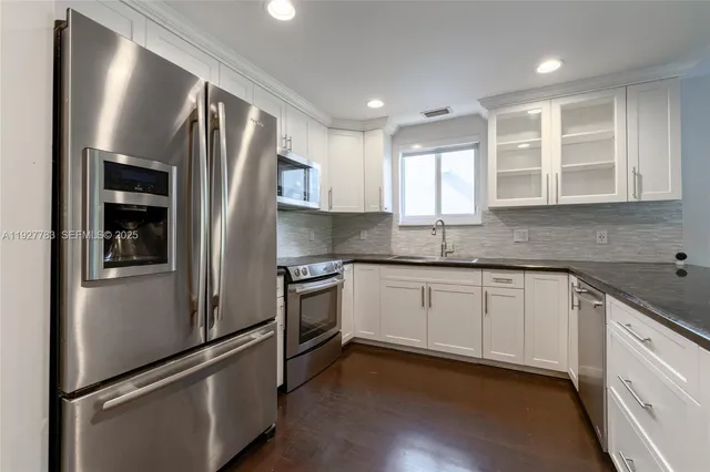 a kitchen with stainless steel appliances granite countertop a refrigerator sink and stove