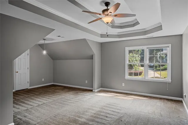 an empty room with fan and windows