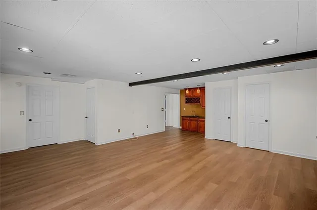 a view of a big room with wooden floor and windows