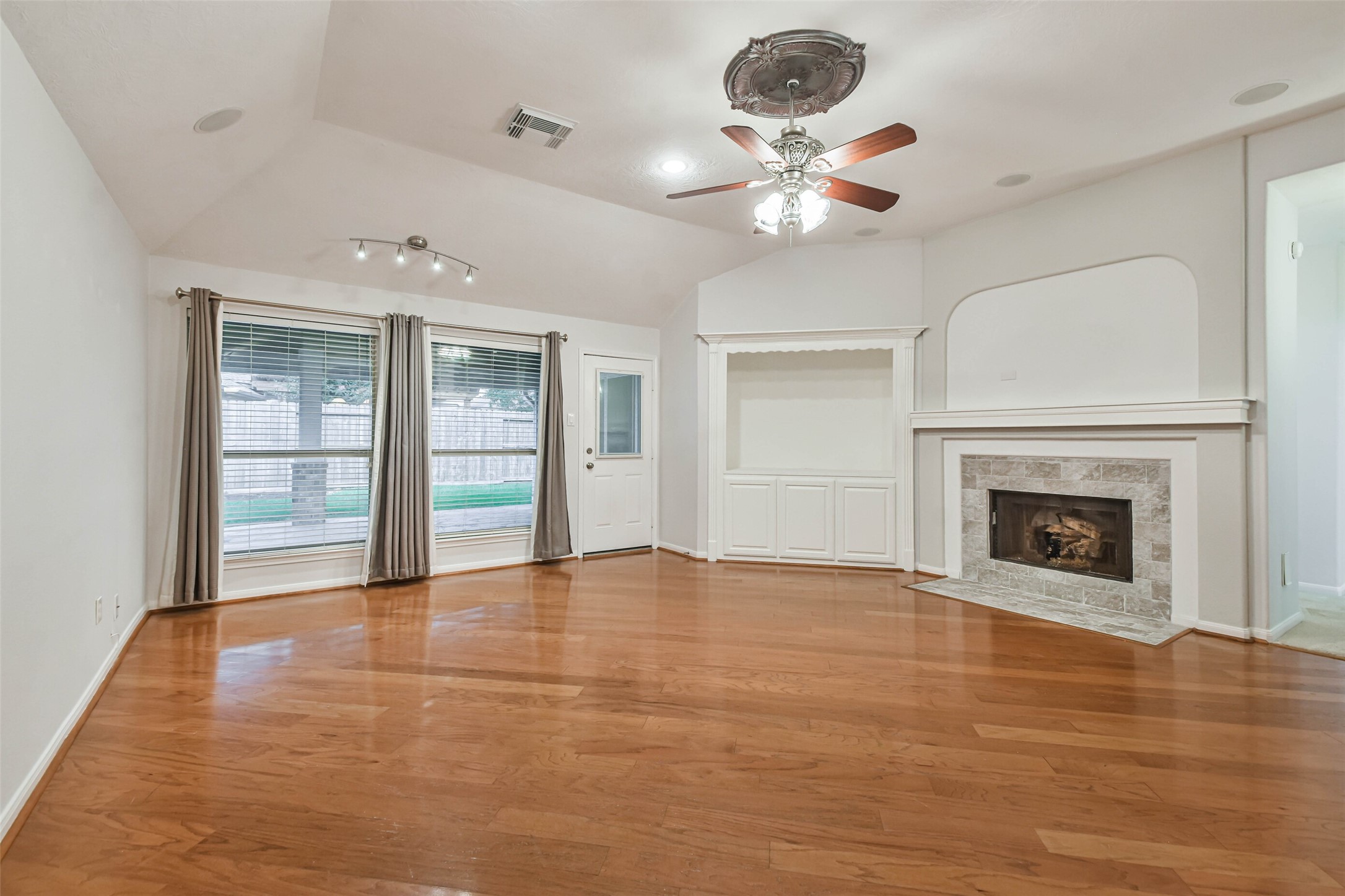 20942 Wind Field Lane Spring, TX 77379 - Photo 22 of 46 a view of an empty room with a fireplace and chandelier fan