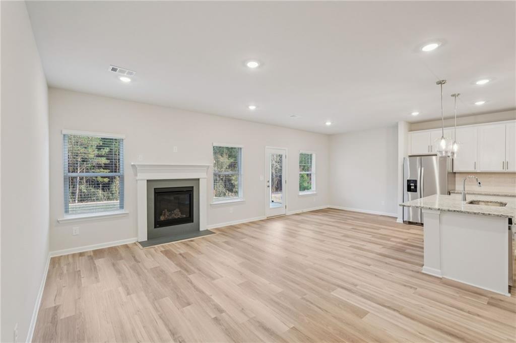 7204 Ensemble Court Fairburn, GA 30213 - Photo 12 of 56 a view of empty room with kitchen and fireplace