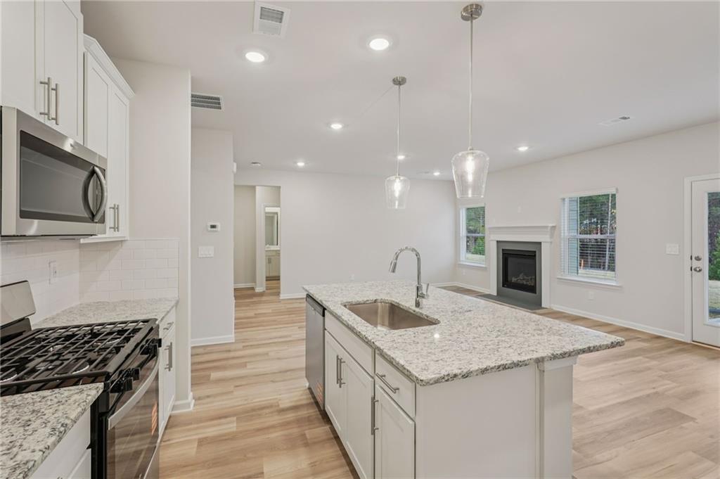 7204 Ensemble Court Fairburn, GA 30213 - Photo 19 of 56 a kitchen with granite countertop kitchen island a sink appliances and a counter top space