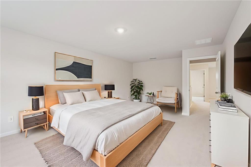 7204 Ensemble Court Fairburn, GA 30213 - Photo 32 of 56 a bedroom with bed and a flat screen tv