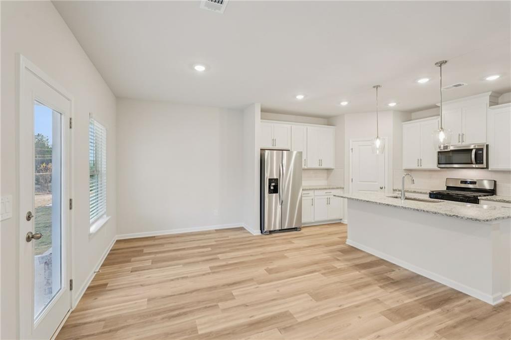 7204 Ensemble Court Fairburn, GA 30213 - Photo 5 of 56 a large kitchen with a refrigerator and a stove top oven