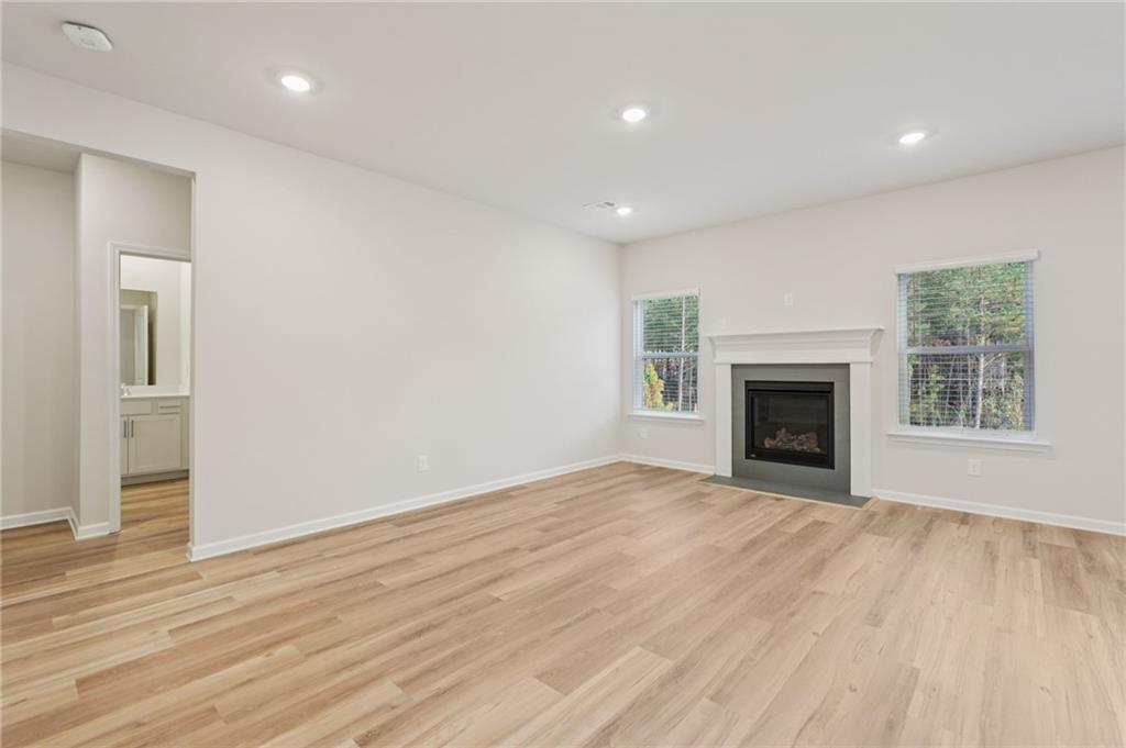 7204 Ensemble Court Fairburn, GA 30213 - Photo 10 of 56 a view of empty room with wooden floor and fireplace