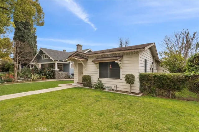 a front view of house with yard and trees in the background
