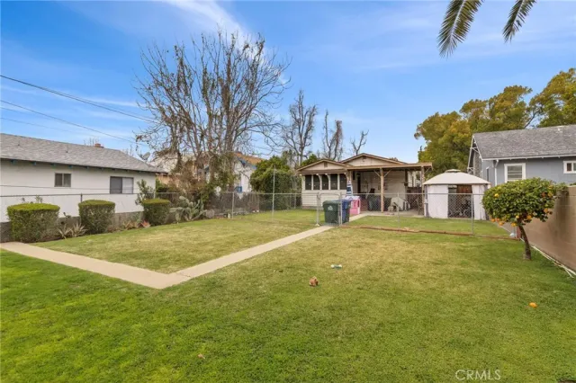 a view of a house with a big yard and palm trees