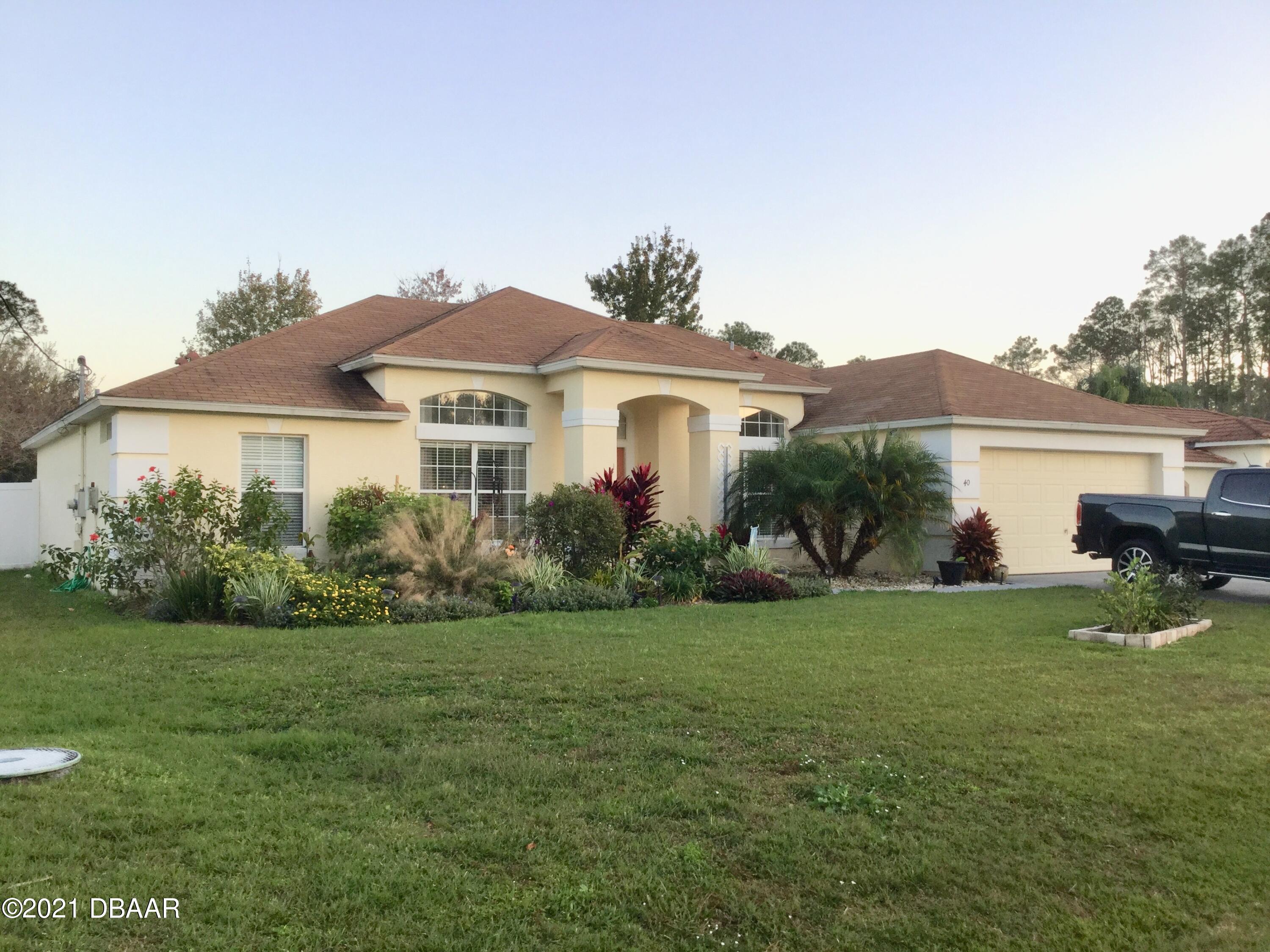 40 Riverside Lane Palm Coast, FL 32164 - Photo 1 of 47 a front view of a house with garden