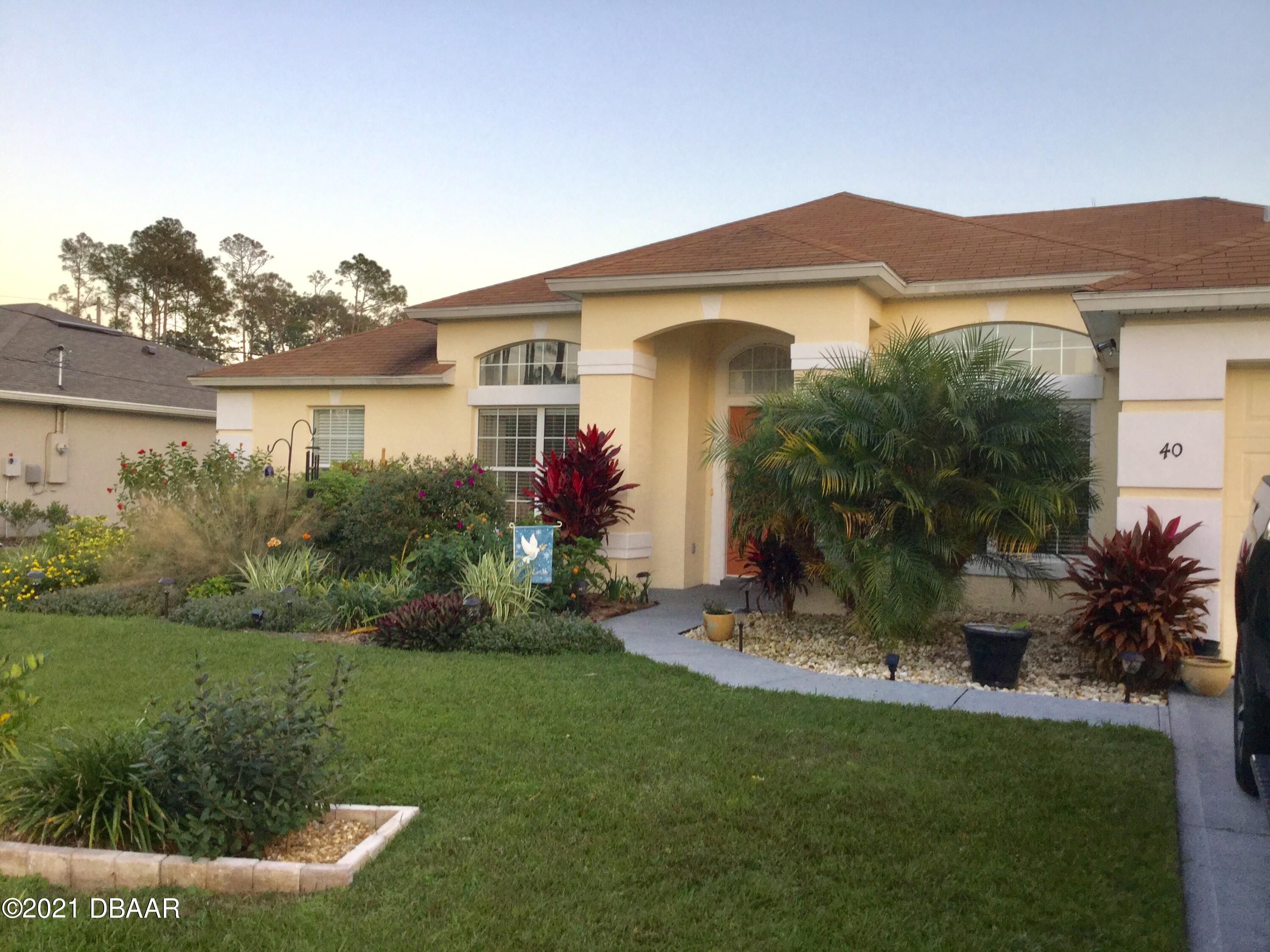 40 Riverside Lane Palm Coast, FL 32164 - Photo 16 of 47 a front view of a house with a yard