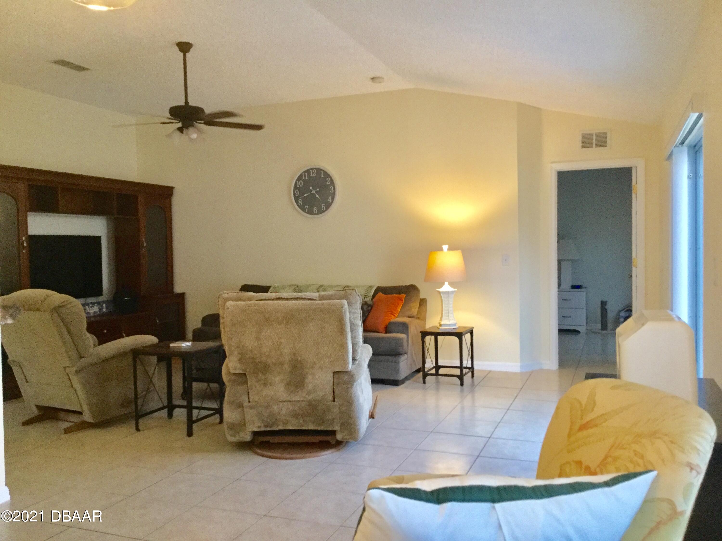 40 Riverside Lane Palm Coast, FL 32164 - Photo 23 of 47 a living room with furniture and a chandelier