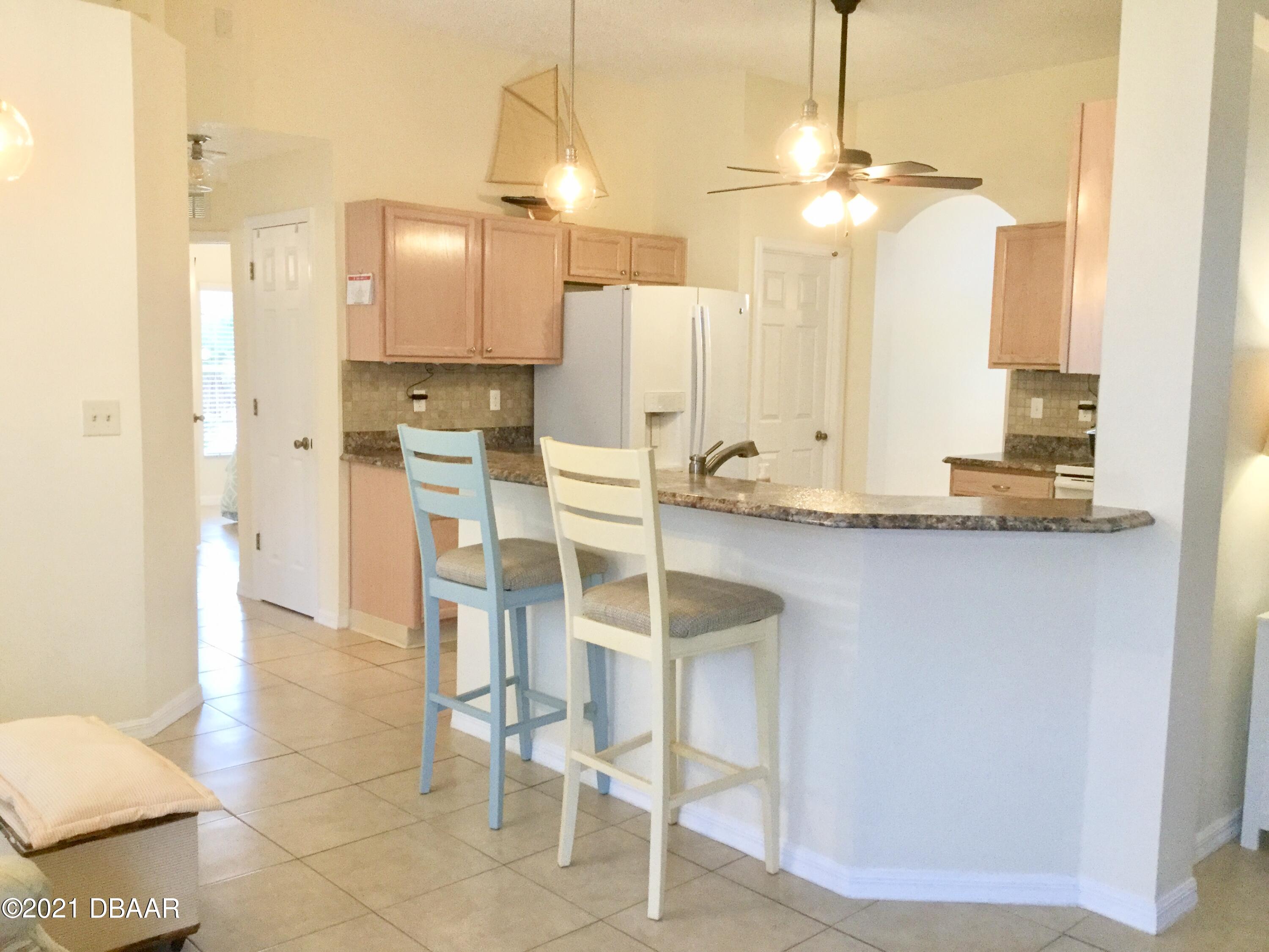 40 Riverside Lane Palm Coast, FL 32164 - Photo 24 of 47 a kitchen with kitchen island granite countertop a table and chairs in it