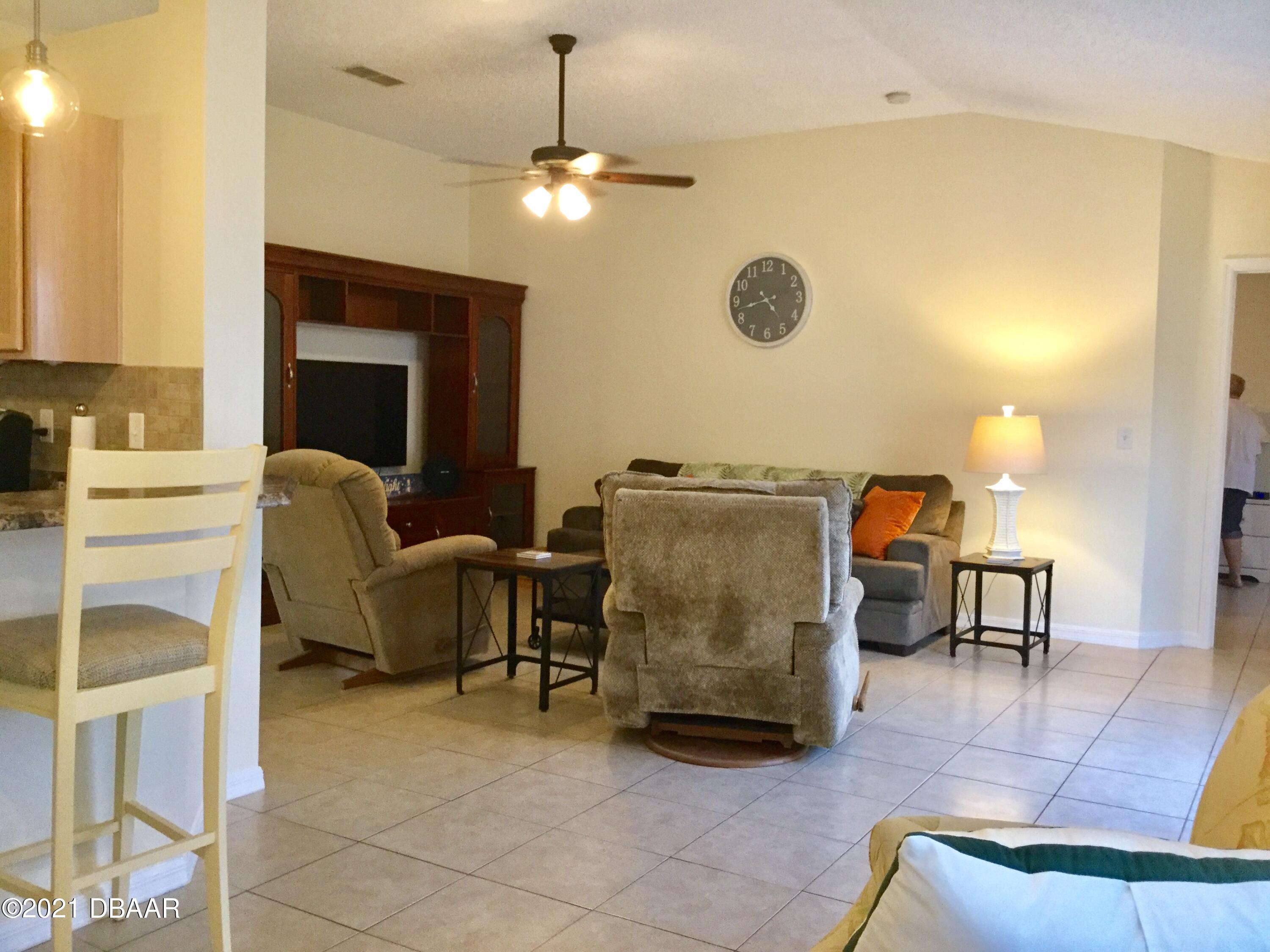 40 Riverside Lane Palm Coast, FL 32164 - Photo 25 of 47 a living room with furniture and a chandelier