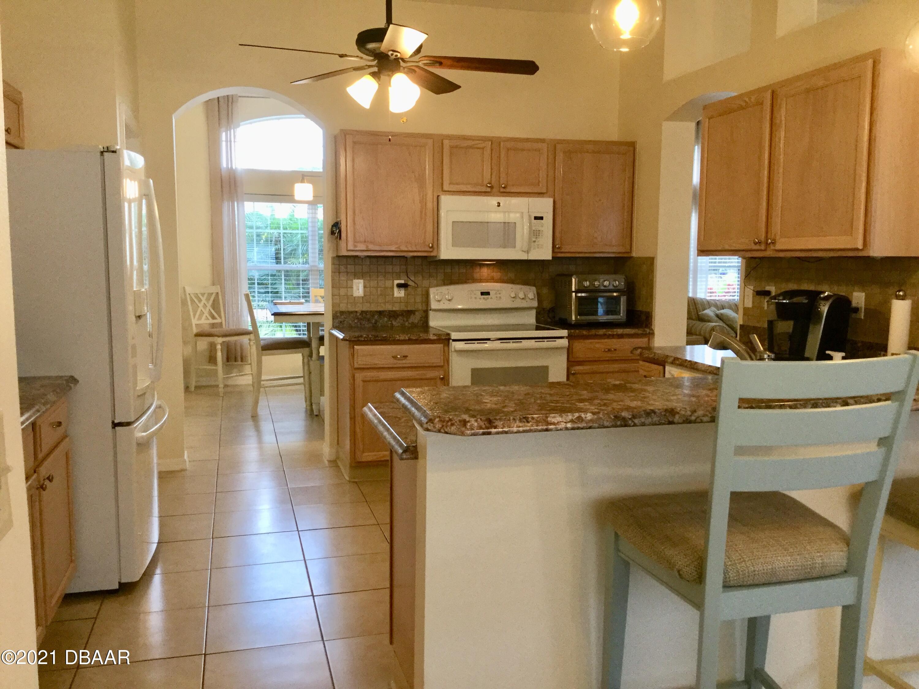 40 Riverside Lane Palm Coast, FL 32164 - Photo 26 of 47 a kitchen with stainless steel appliances granite countertop a stove a sink and a refrigerator