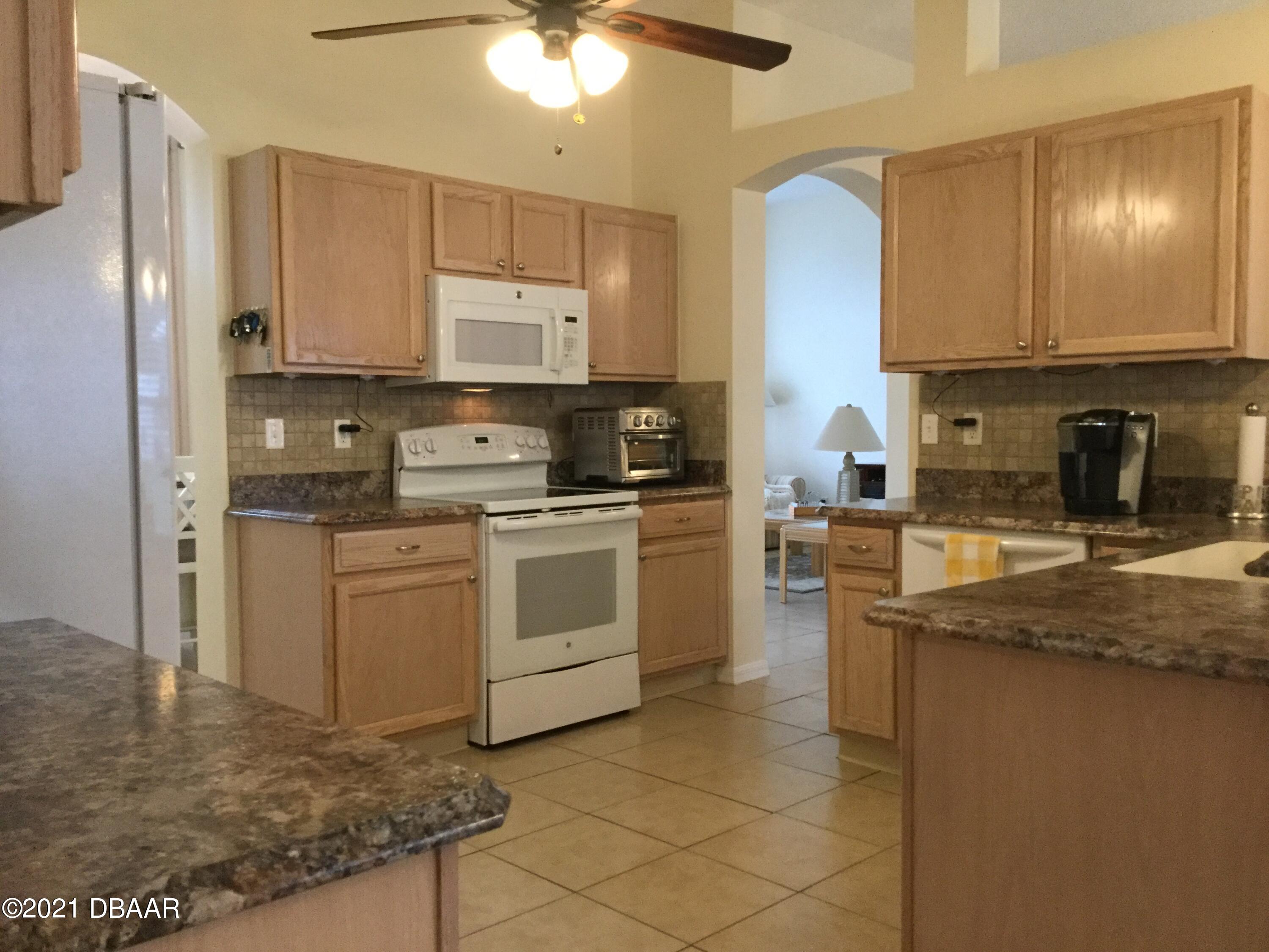 40 Riverside Lane Palm Coast, FL 32164 - Photo 27 of 47 a kitchen with a sink stove and cabinets