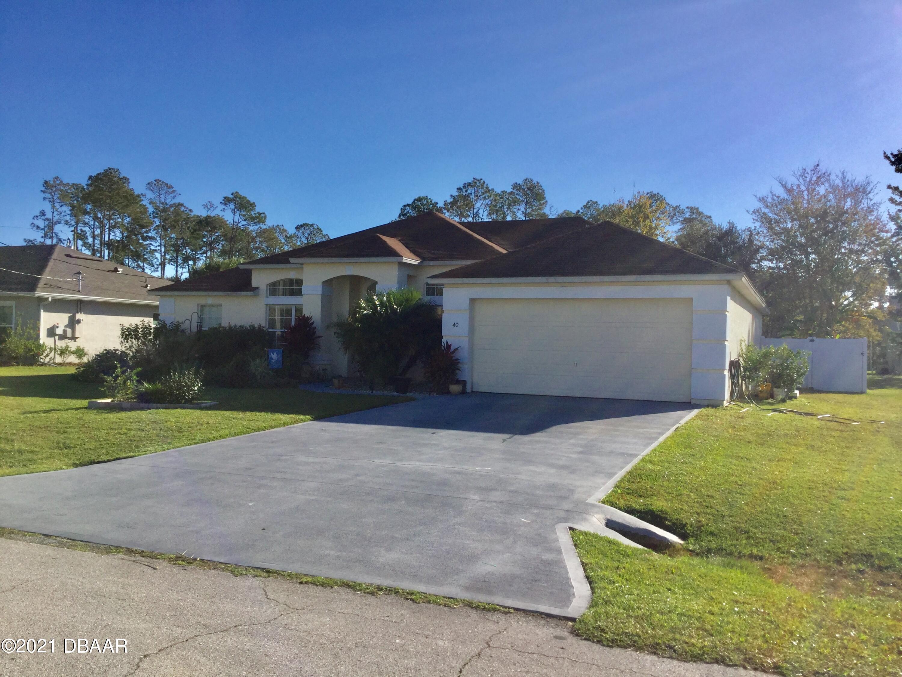 40 Riverside Lane Palm Coast, FL 32164 - Photo 4 of 47 a front view of a house with garden