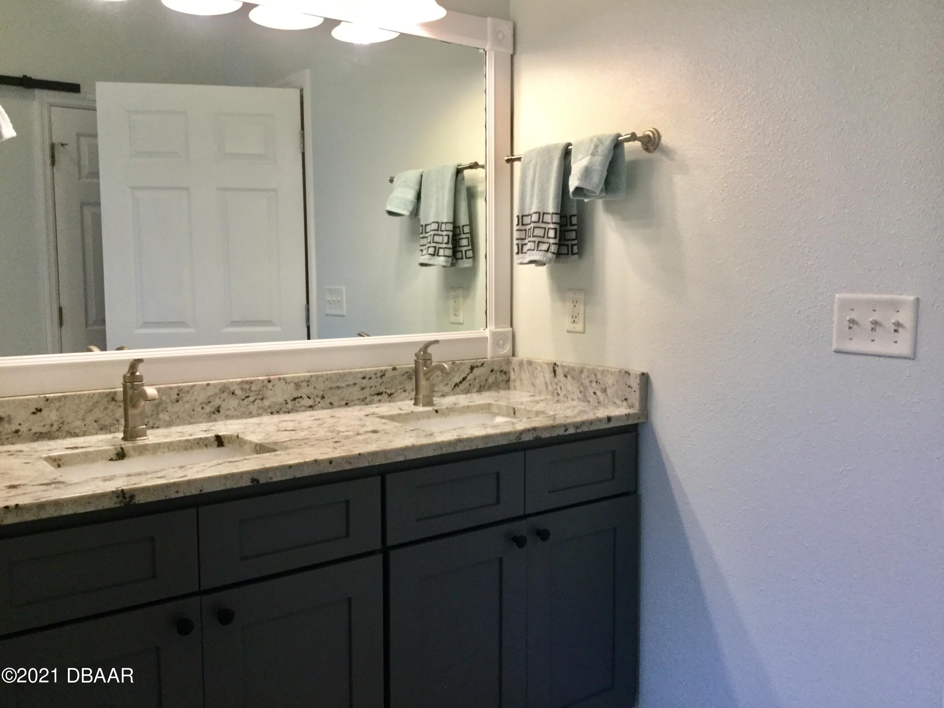 40 Riverside Lane Palm Coast, FL 32164 - Photo 41 of 47 a bathroom with a granite countertop sink and a mirror