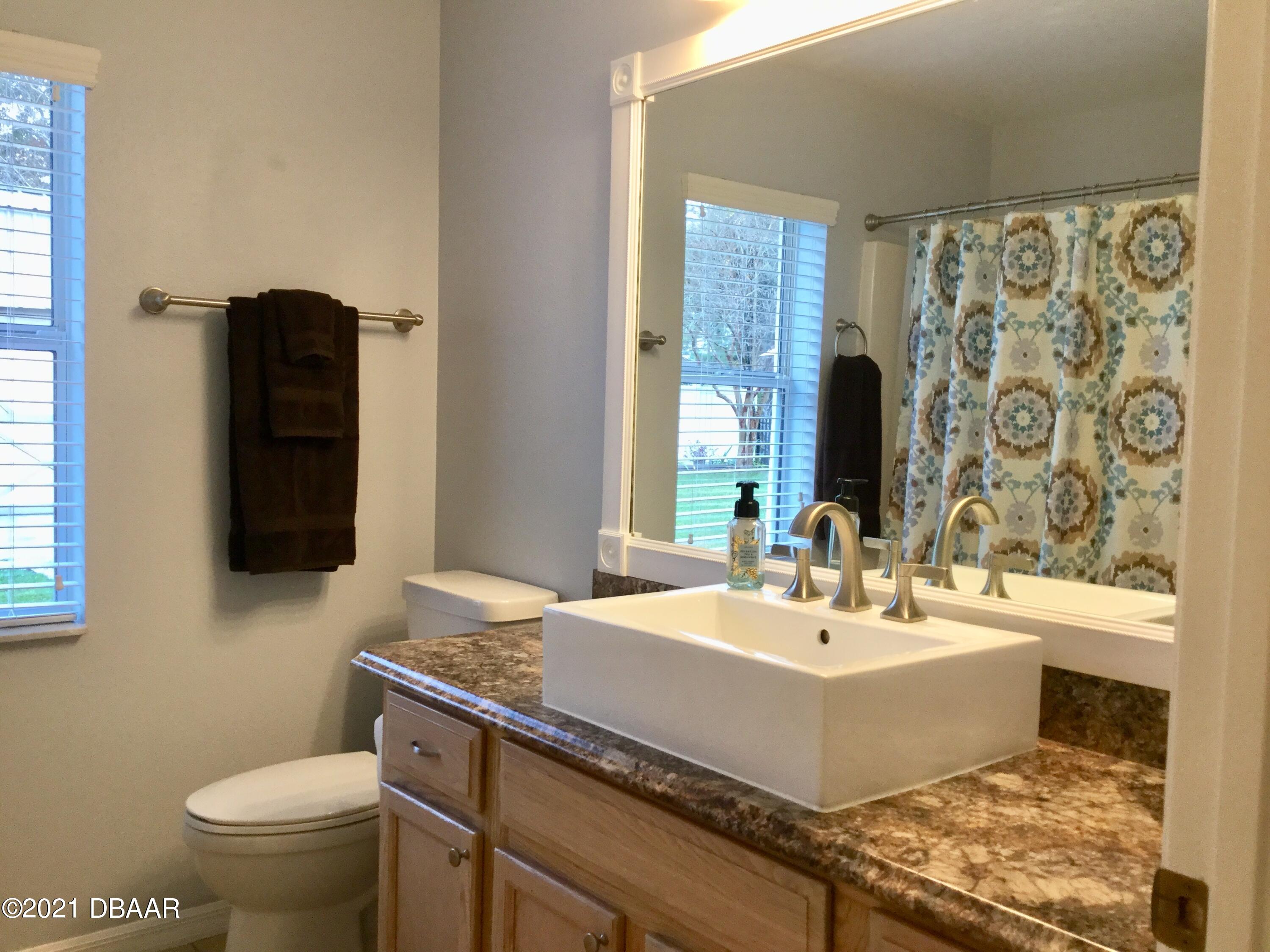 40 Riverside Lane Palm Coast, FL 32164 - Photo 42 of 47 a bathroom with a sink and a mirror