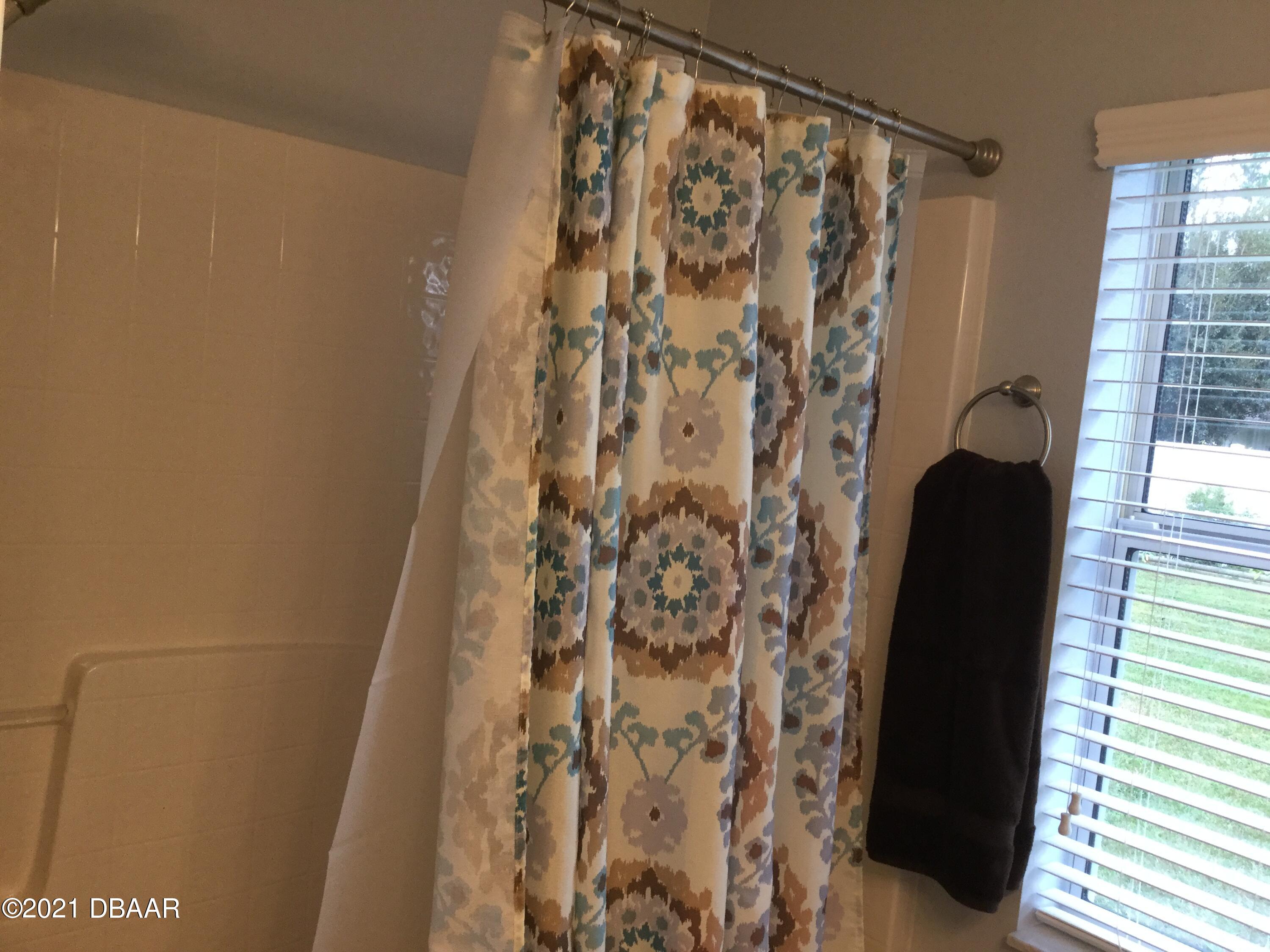 40 Riverside Lane Palm Coast, FL 32164 - Photo 43 of 47 a bathroom with a shower and a shower curtain