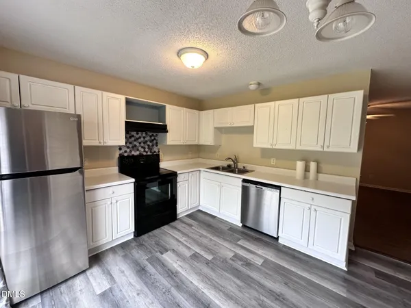 a kitchen with a refrigerator stove and white cabinets