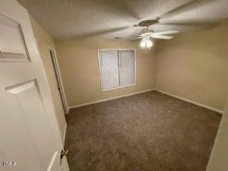 en empty room with windows and fan