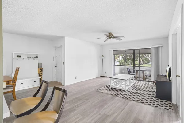 a living room with furniture floor to ceiling window and a rug