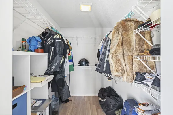 a view of walk in closet with clothes and shoes