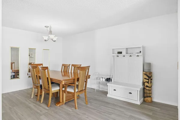 a dining room with furniture a chandelier and wooden floor