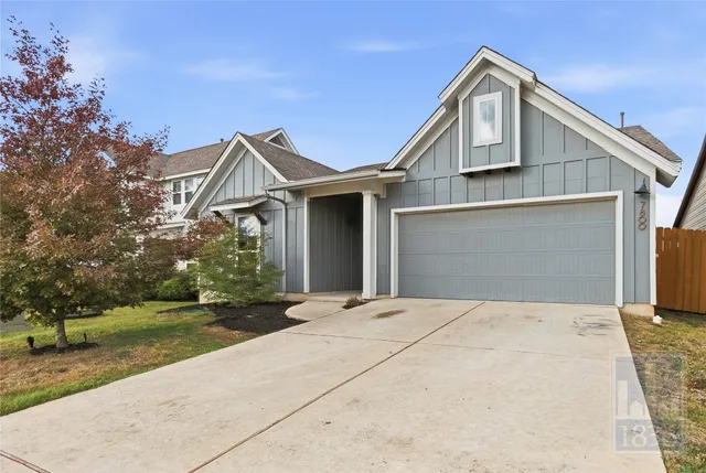 a front view of a house with a garden and trees
