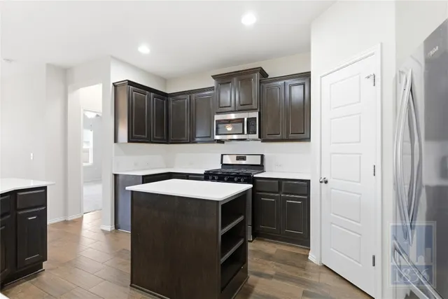 a kitchen with stainless steel appliances a sink stove refrigerator and cabinets