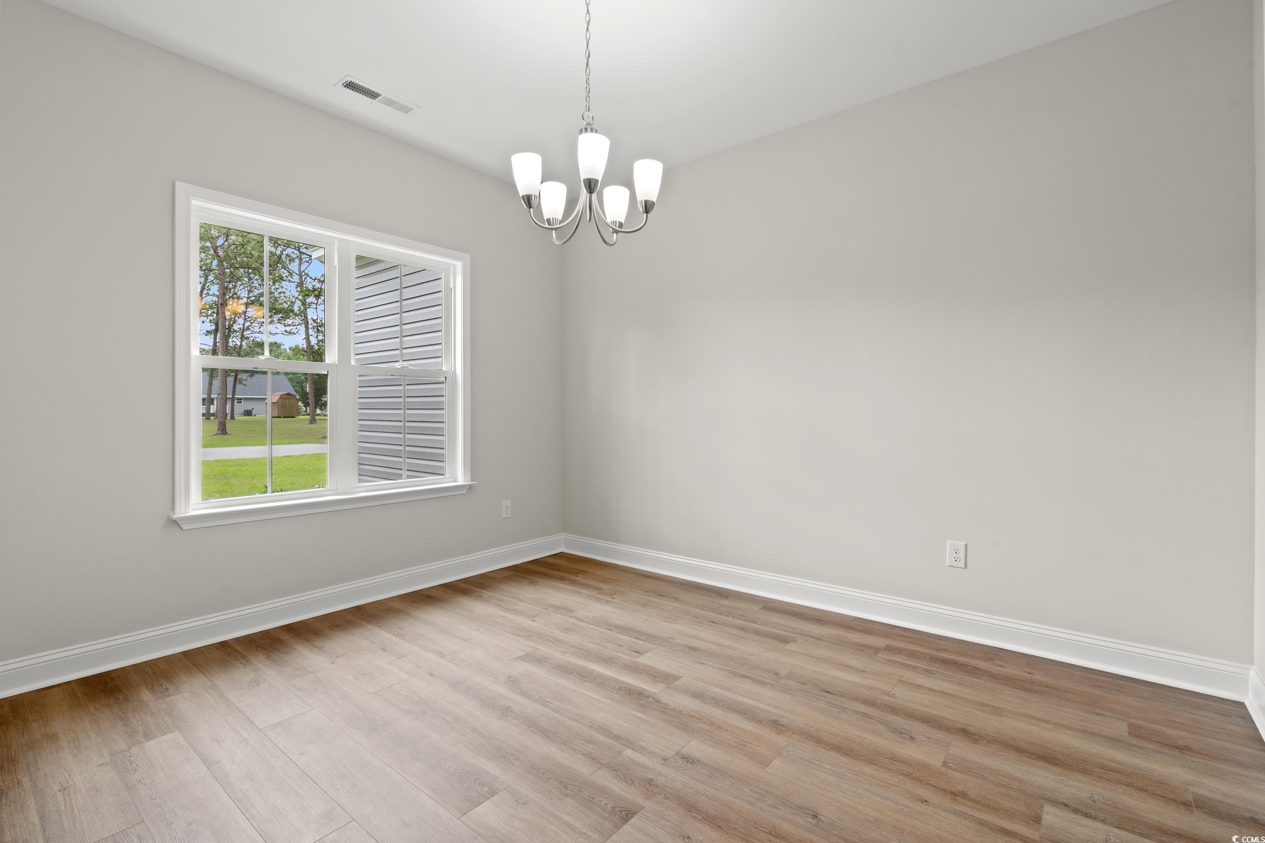 2612 Old Charleston Road Georgetown, SC 29440 - Photo 3 of 34 Spare room featuring a chandelier, baseboards, lig