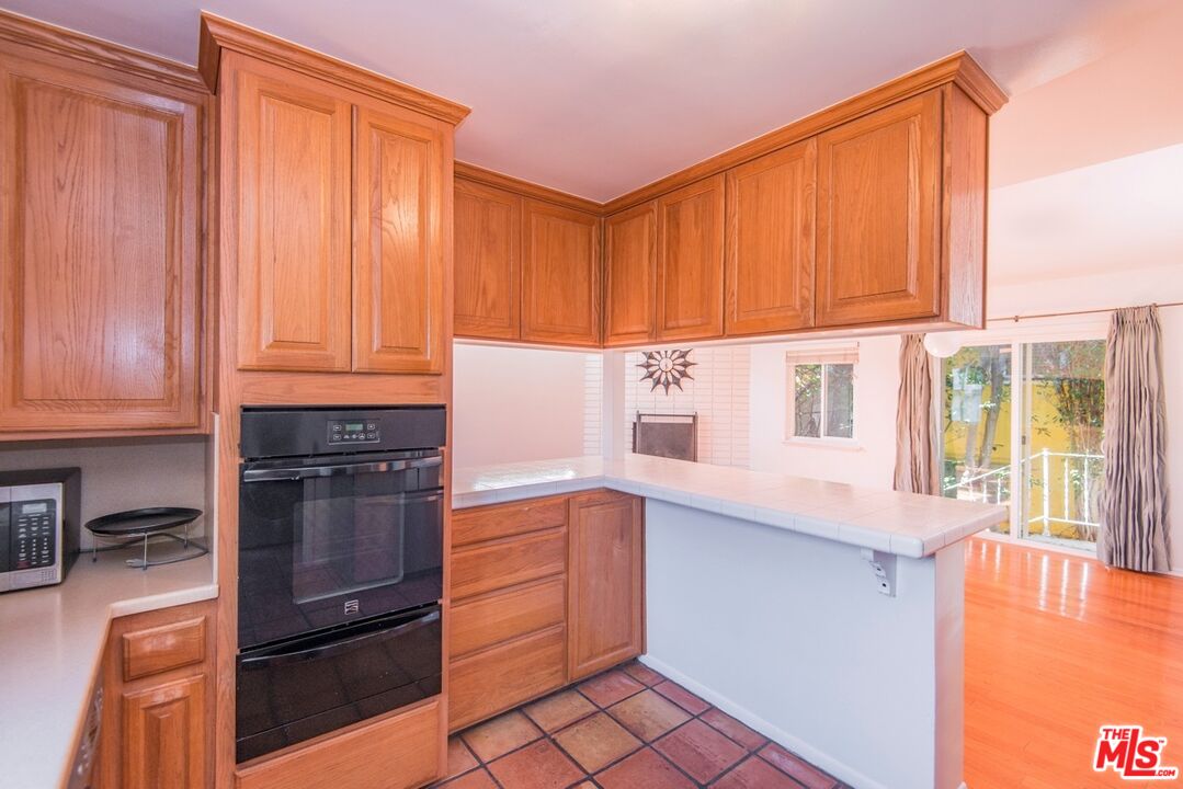 8531 Walnut Drive Los Angeles, CA 90046 - Photo 8 of 17 a kitchen with stainless steel appliances granite countertop a refrigerator a stove and a sink with cabinets