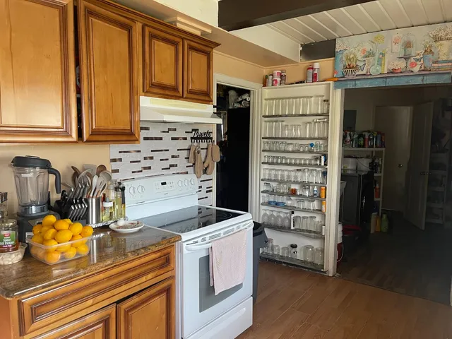 a kitchen with stainless steel appliances kitchen island granite countertop a stove and a sink