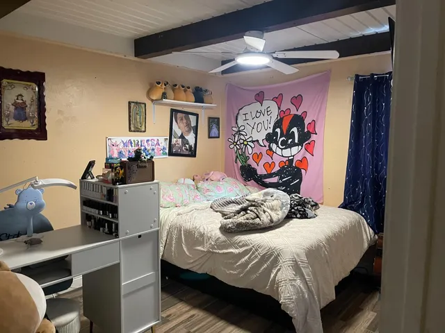 a bedroom with a bed and a wall painting