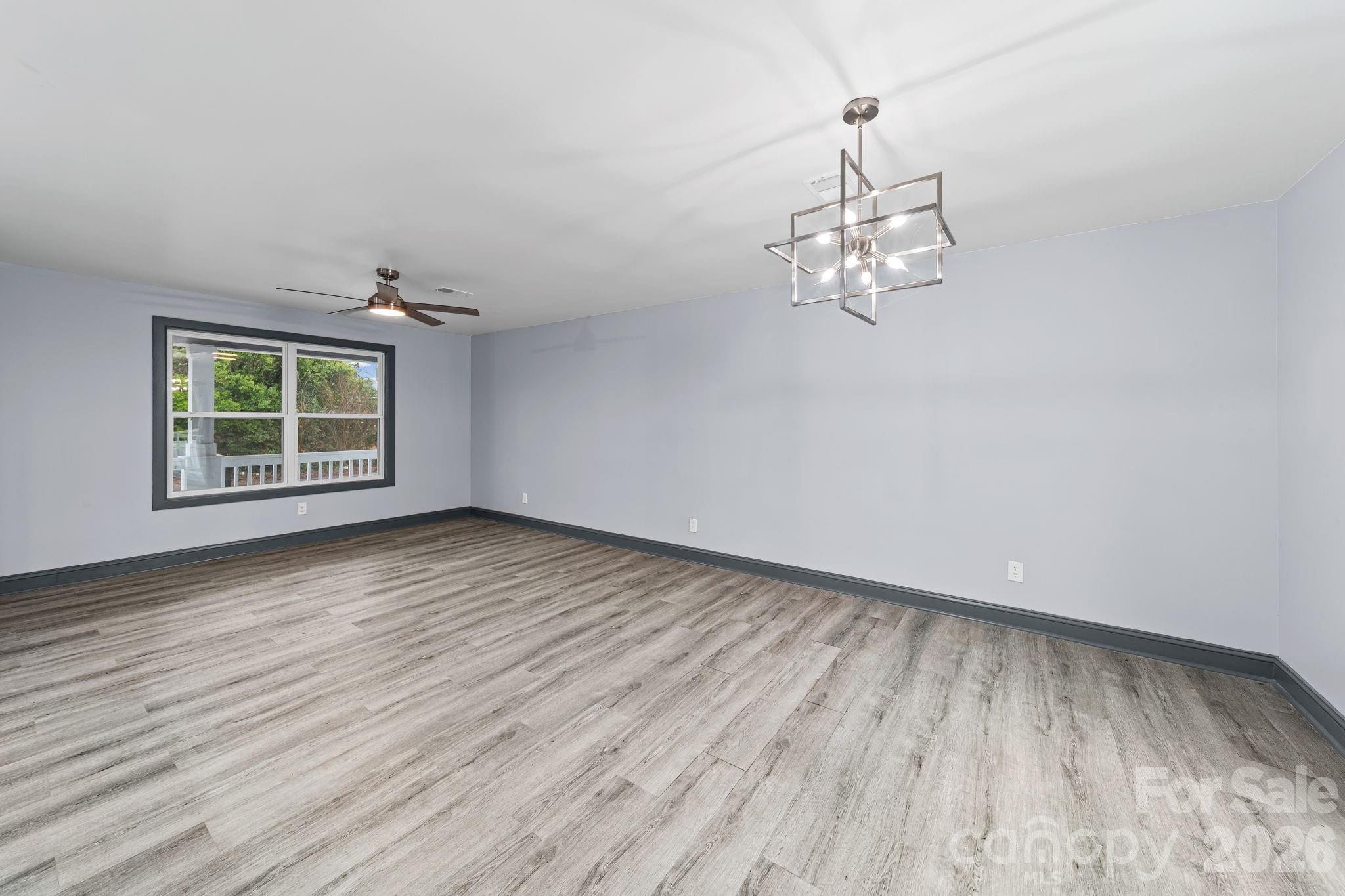 109 Haddock Road Northwest Orangeburg, SC 29115 - Photo 16 of 48 an empty room with wooden floor chandelier and windows