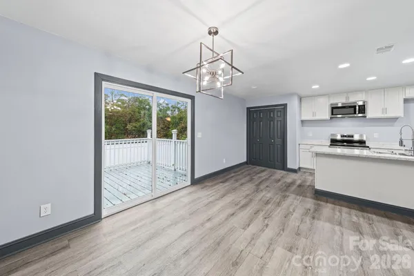 a view of a kitchen with wooden floor and outdoor space