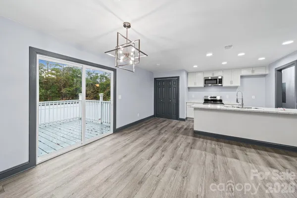 a view of a kitchen with wooden floor and a ceiling fan