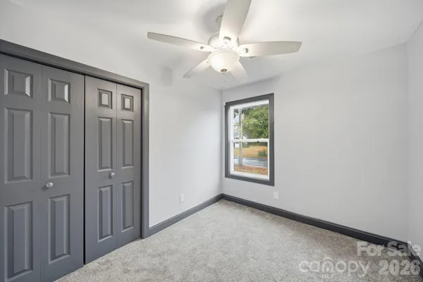 an empty room with windows and closet
