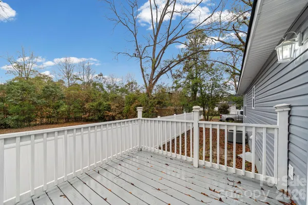 a view of deck with wooden floor and fence and trees
