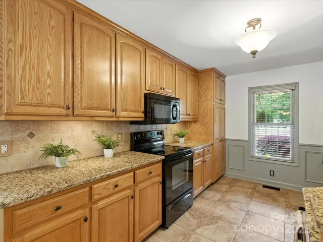 a kitchen with stainless steel appliances granite countertop a stove sink and cabinets