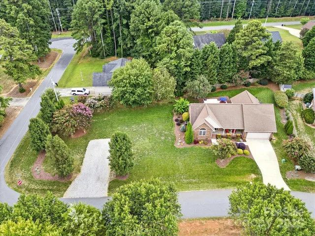 an aerial view of a house with a yard and lake view