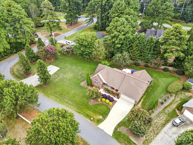 an aerial view of a house with a yard and lake view