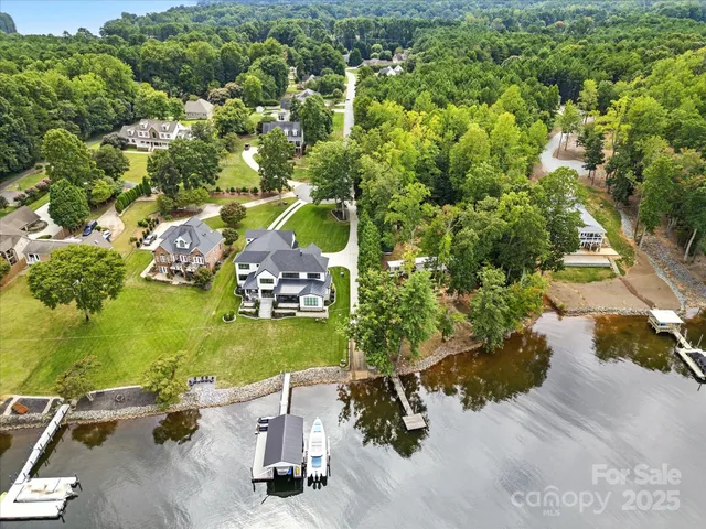an aerial view of a house with a yard and lake view