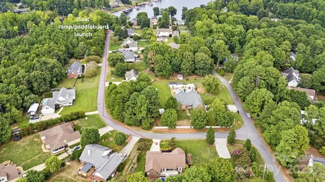 an aerial view of a residential houses with outdoor space and trees all around