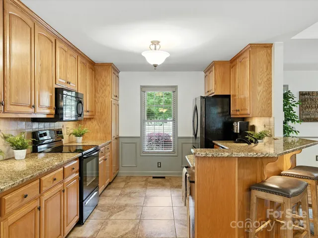 a kitchen with stainless steel appliances granite countertop a sink refrigerator and cabinets