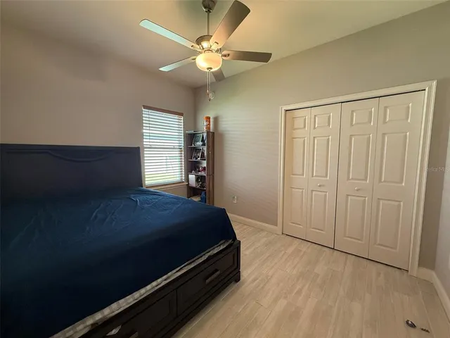 a bedroom with a bed and a ceiling fan