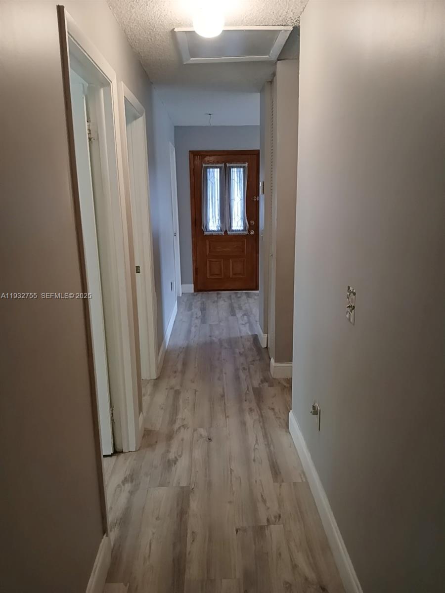 10210 Southwest 175th Street Miami, FL 33157 - Photo 13 of 14 a view of a hallway with wooden floor and a living room